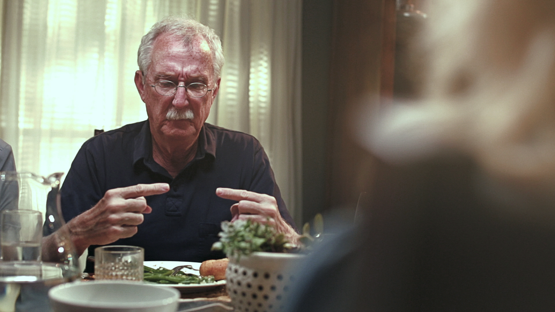 Film still. Bob at the dinner table
