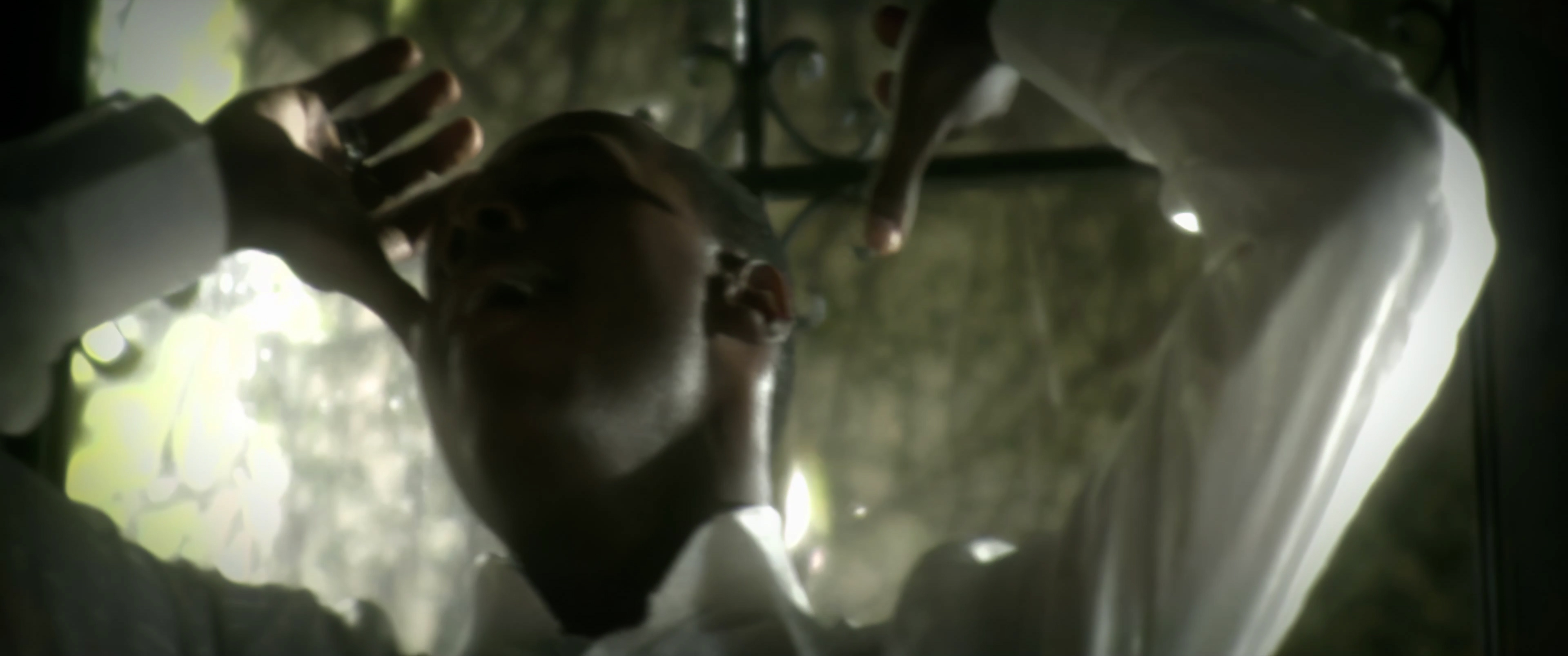 Micah Stampley close-up, head tilted back, arms mid-gesture at the villa gate